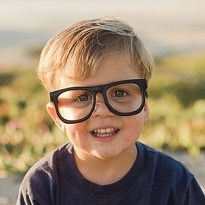 Smiling child wearing glasses at beach