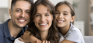 parents and daughter hugging and smiling
