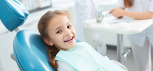 smiling child in a dentist’s chair