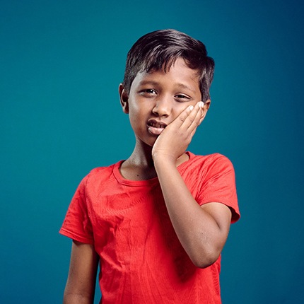 child holding his face in pain