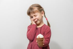 little girl holding an ice cream cone and her face